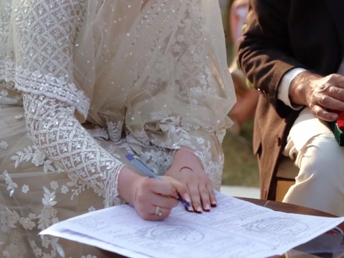 Zayna & Mustafa · Signing the Nikkah. Zayna signs the Nikkah document.